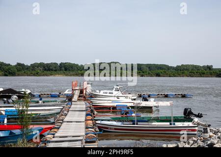 Photo de bateaux de différentes tailles sur le Danube ancré sur un quai, un petit port, dans l'après-midi à Novi Banovci Serbie, au printemps Banque D'Images