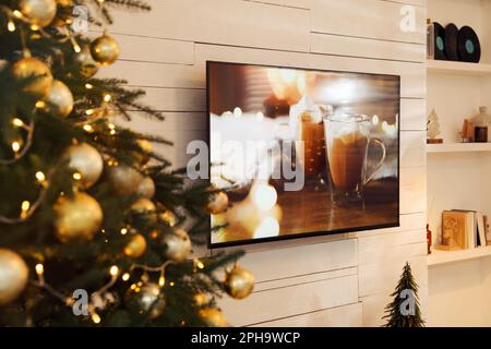 TV plasma sur un mur en bois blanc dans le salon joliment décoré pour Noël Banque D'Images