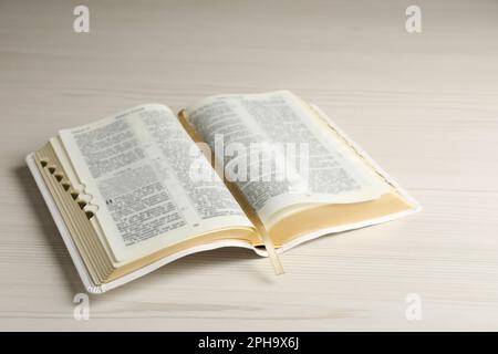 Ouvrez la Bible sur une table en bois blanc. Livre religieux chrétien Banque D'Images