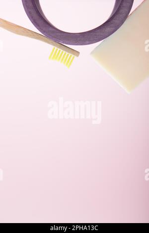 Composition d'une brosse à dents en bambou, d'un savon et d'une arche en bois sur fond rose. Le concept de l'hygiène de routine et des soins personnels. Matériaux écologiques et l Banque D'Images