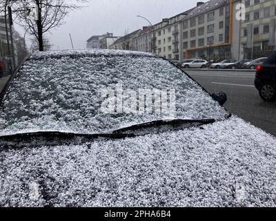 Hambourg, Allemagne. 27th mars 2023. Des pierres de grêle couvrent une voiture. La grêle a pris les gens par surprise. Peu de temps avant, le soleil avait brillé. Credit: Thomas Müller/dpa/Alay Live News Banque D'Images