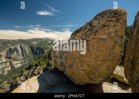 Les rochers glaciaires se trouvent sur le bord de Taft point et surplombent les chutes de Yosemite au loin la journée d'été Banque D'Images