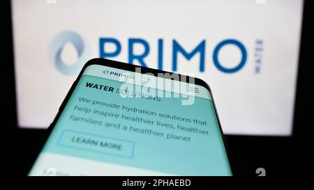 Téléphone mobile avec la page web de la société Primo Water Corporation à l'écran devant le logo de l'entreprise. Faites la mise au point dans le coin supérieur gauche de l'écran du téléphone. Banque D'Images