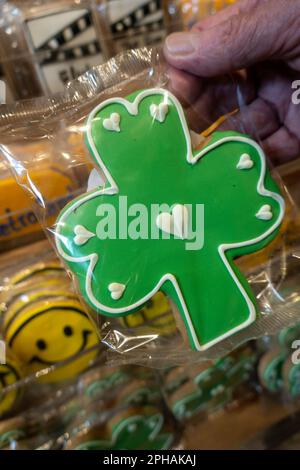 Un client tient un biscuit en forme de Shamrock pour bonne chance près de Saint Patrick Day, Grand Central, Market, 2023, New York City, ÉTATS-UNIS Banque D'Images