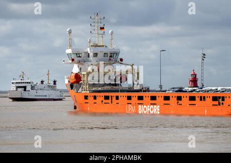 Emden, Allemagne. 27th mars 2023. Un cargo d'UPM Biofore repose contre un mur de quai dans le port extérieur, tandis que le ferry de l'île « Westfalen » de la compagnie maritime AG-EMS entre dans le port. Le ministère de l'économie de Basse-Saxe, l'autorité portuaire de Basse-Saxe et les compagnies ports maritimes de Niedersachsen, Niedersachsen ports et JadeWeserPort Realizierungs GmbH & Co KG a présenté un rapport sur la situation actuelle des ports maritimes de Basse-Saxe lors d'une conférence de presse. Credit: Hauke-Christian Dittrich/dpa/Alay Live News Banque D'Images