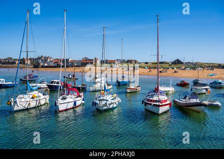 Bateaux amarrés dans le port d'Elie avec la plage et la ville d'Elie en arrière-plan - Elie, Neuk est de Fife, Écosse, Royaume-Uni Banque D'Images