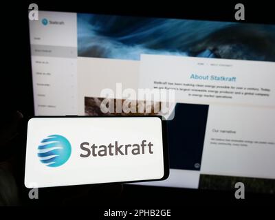 Personne tenant un smartphone avec le logo de la société norvégienne d'hydroélectricité Statkraft COMME à l'écran devant le site Web. Mise au point sur l'affichage du téléphone. Banque D'Images