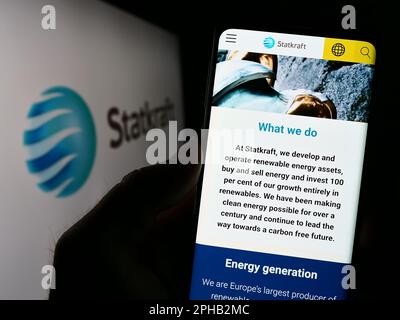 Personne tenant un smartphone avec le site web de la société norvégienne d'hydroélectricité Statkraft COMME à l'écran devant le logo. Concentrez-vous sur le centre de l'écran du téléphone. Banque D'Images