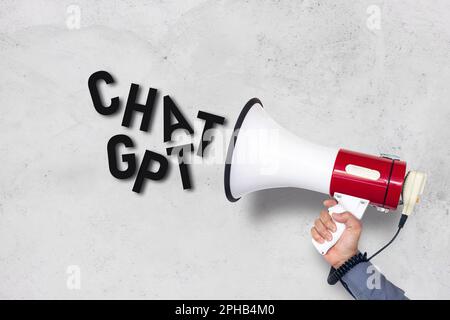 Main de l'homme tenant le mégaphone et le message Chat GPT sur fond de mur de brique blanche . concept de technologie Banque D'Images