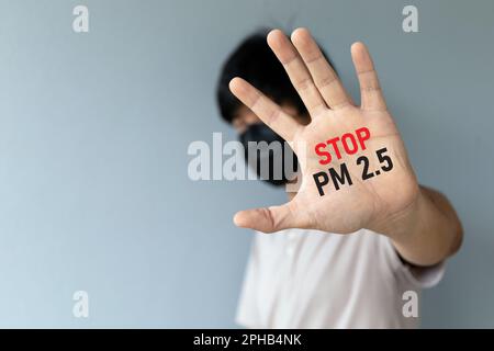 Hommes portant un masque pour protéger la pollution de l'air et PM2,5 poussière avec montrer main de paume. Arrêtez PM 2,5. mise au point douce et sur-éclairage en arrière-plan Banque D'Images