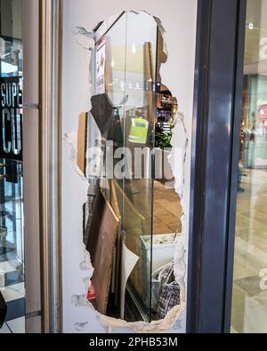 Brême, Allemagne. 27th mars 2023. Un trou est visible dans le mur d'un barbershop du centre commercial Roland-Centre de Brême-Huchting. Au cours du week-end, selon la police, les cambrioleurs avaient ouvert les murs de plusieurs magasins afin d'accéder par eux aux vitrines d'un magasin de bijoux, d'où ils ont volé des bijoux d'une valeur encore non quantifiée. Credit: Focke Strangmann/dpa/Alay Live News Banque D'Images