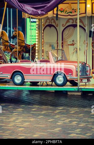 Voiture rose sur un carrousel pour enfants Banque D'Images
