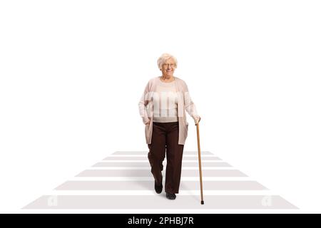 Portrait complet d'une femme âgée avec une canne à pied à une traversée piétonne isolée sur fond blanc Banque D'Images