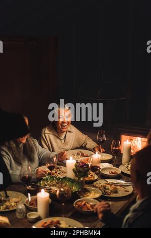 Bonne femme âgée avec des amis qui apprécient de manger à la fête du dîner Banque D'Images
