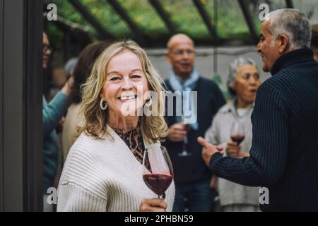 Portrait d'une femme âgée heureuse avec des amis lors d'un dîner Banque D'Images