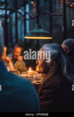 Femme sénior parmi des amis lors d'une soirée dîner Banque D'Images