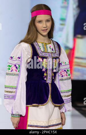 Moscou, Russie. 26th mars 2023. Les modèles présentent un costume national sur une piste dans le cadre du spectacle « bords du monde » au festival de mode pour enfants de la semaine de la mode des enfants au magasin central pour enfants de Lubyanka à Moscou, en Russie Banque D'Images