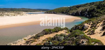 Vue panoramique sur Praia da Amoreira avec une eau cristalline, une rive sablonneuse et les falaises environnantes, capturées d'un point de vue élevé. Banque D'Images