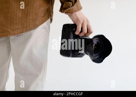 Photographe prêt à travailler, tenant l'appareil photo moderne à la main, gros plan rogné Banque D'Images