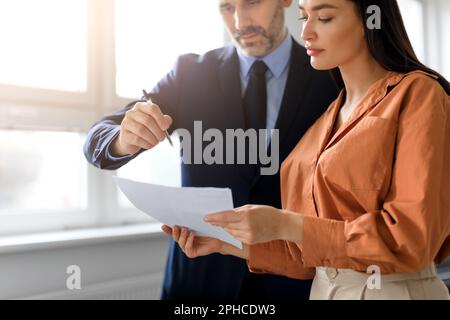 Travail d'équipe sur le lieu de travail. Homme d'affaires et femme d'affaires lisant le rapport financier et parlant, regardant le document, rogné Banque D'Images