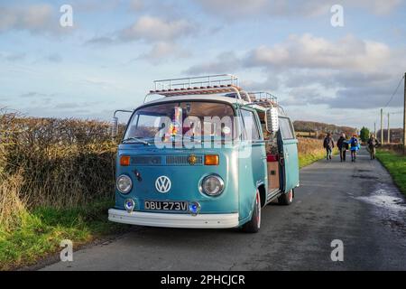 Volkswagen « Bay Window », camping-car stationné sur une voie de campagne près de Hoober, dans le Yorkshire du Sud, avec un groupe de marcheurs qui descendent sur la voie derrière Banque D'Images