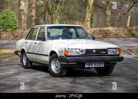 Toyota Cressida DX 1982 garé sur une route de banlieue avec des arbres et un parc derrière Banque D'Images