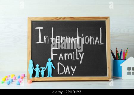 Bonne journée en famille. Composition avec tableau noir et papeterie sur table en bois blanc Banque D'Images