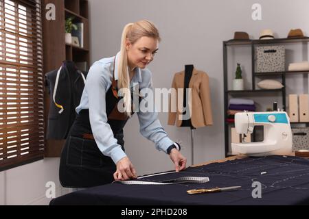 Couturière avec mètre ruban travaillant en atelier Banque D'Images