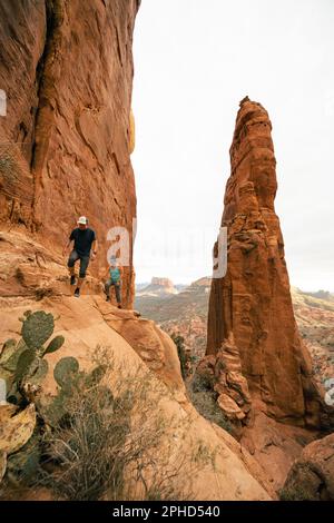 Jeune couple randonnée au sommet Cathedral Rock à Sedona, Arizona, à l'heure d'or. Banque D'Images