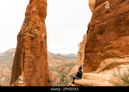 Une femme regarde en riant au point de vue du sommet de Cathedral Rock. Banque D'Images