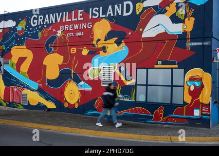 Deux personnes se promeunaient devant une fresque sur l'édifice Granvile Island Brewing Company, à Granville Island, Vancouver, C.-B., Canada Banque D'Images