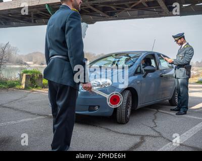 Cremona, Italie - février 2023 deux agents de police fiscale en service près du pont de la ville du fleuve po, à la frontière de la Lombardie et de l'Emilie-Romagne Banque D'Images