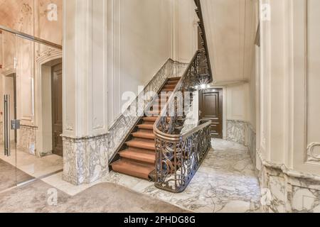 un escalier dans une maison avec sol en marbre et finitions blanches sur les murs, escaliers menant au deuxième étage Banque D'Images