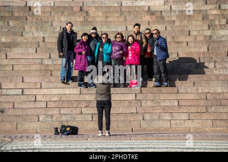 Les touristes asiatiques posant pour une photo de groupe sur les marches de la cathédrale d'Helsinki lors d'une journée de printemps ensoleillée dans le quartier Kruununhaka d'Helsinki, en Finlande Banque D'Images