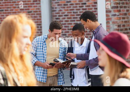 Permettez-moi de prendre une photo de vos notes. un groupe d'étudiants de l'université regardant leurs notes ensemble sur le campus. Banque D'Images