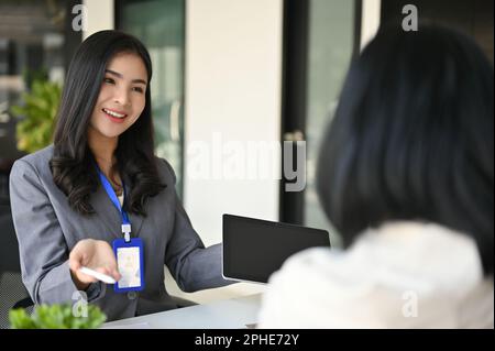 Une femme de banque asiatique ou un consultant financier attirante et charmante du millénaire expliquant une nouvelle campagne d'investissement financier à un client. Banque D'Images