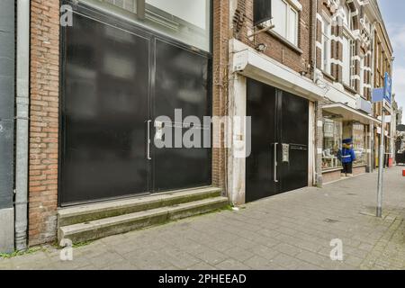 Extérieur d'un immeuble résidentiel à plusieurs étages à la lumière du jour avec restaurants portes vitrées des boutiques au rez-de-chaussée situé sur la rue avec promenade pavée Banque D'Images