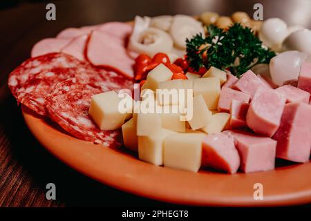 Un assortiment de viandes et de fromages soigneusement disposés sur une assiette, prête pour la cuisson Banque D'Images