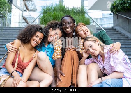 Portrait en vue de face d'un groupe heureux d'amis multiraciaux regardant l'appareil photo, en plein air, multi-ethniques gaies jeunes femmes adolescentes Banque D'Images