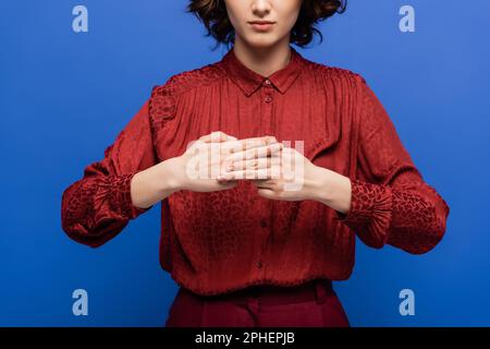 vue rognée de l'enseignant montrant le mot de nom avec les mains tout en apprenant à utiliser le langage des signes isolé sur bleu, image de stock Banque D'Images