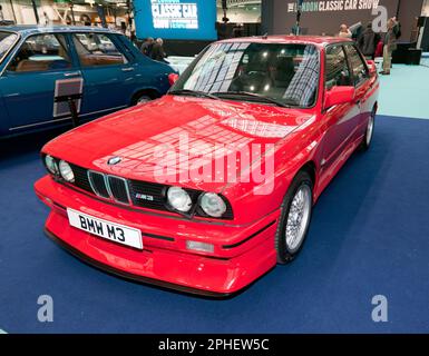 Vue des trois quarts avant d'une BMW M3 rouge de E30 générations, exposée, au London Classic car Show 2023 Banque D'Images