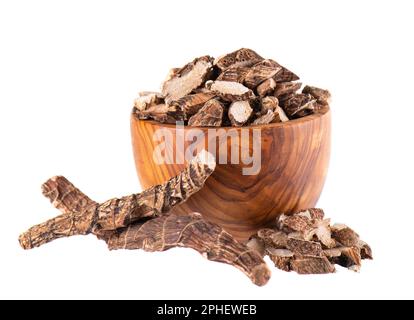 Racine de calamus dans un bol en bois, isolée sur fond blanc. Drapeau doux, balancement ou racine de rat musqué. Racine sèche d'Acorus calamus. Banque D'Images