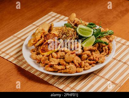 Une plaque en céramique peu profonde avec une grande variété d'aliments frits Banque D'Images