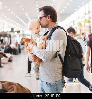 Père voyageant avec un enfant, tenant son bébé garçon au terminal de l'aéroport attendant de monter à bord d'un avion. Concept voyage avec enfants Banque D'Images