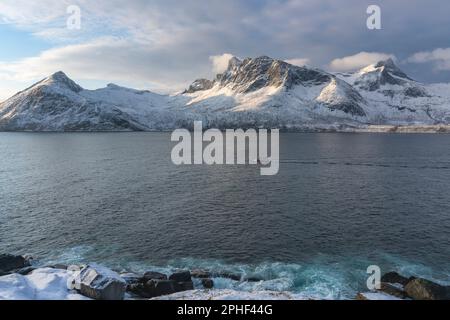 Fischer am Morgen, Schiff im Øyfjorden, mit den schneebematten Bergen von Senja, genannt Segla, Kongan und Skuran im hintergrund. Norwegen Banque D'Images