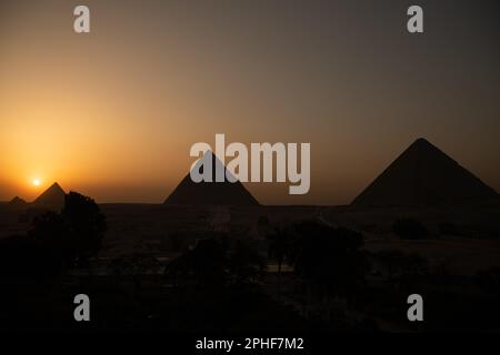 Vue sur les pyramides de Gizeh au coucher du soleil en Égypte Banque D'Images