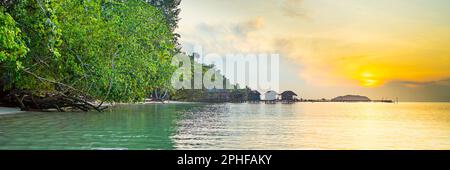 Lever du soleil sur la côte de Saporkren, Raja Ampat en arrière-plan détruit des maisons d'eau, Papouasie occidentale Banque D'Images