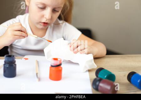 une petite fille peint un renard jouet en argile. Concept DIY. Banque D'Images