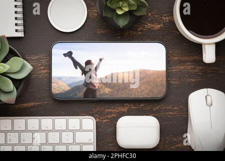 le téléphone portable est sur la table. planifier un voyage ou regarder un film de photos sur le lieu de travail au bureau ou à la maison. pause-café ou succès dans Banque D'Images