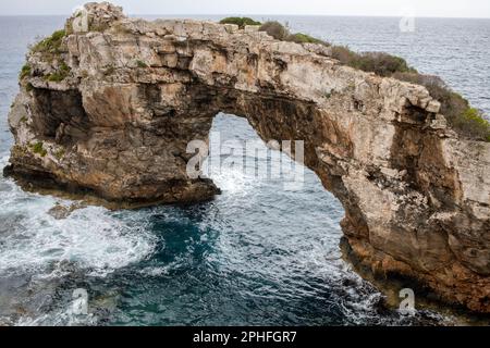Vue aérienne d'une majestueuse arche naturelle au-dessus de l'océan, avec des falaises vertigineuses sortant des eaux cristallines Banque D'Images